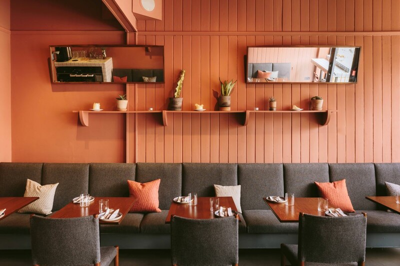 Long Friday, Newcastle upon Tyne — modern, minimalist restaurant interior with terracotta walls, grey banquette seating, soft cushions and potted plants — North East regional winner, Best Local Restaurant 2025 in The Good Food Guide. Photo by Nigel John.